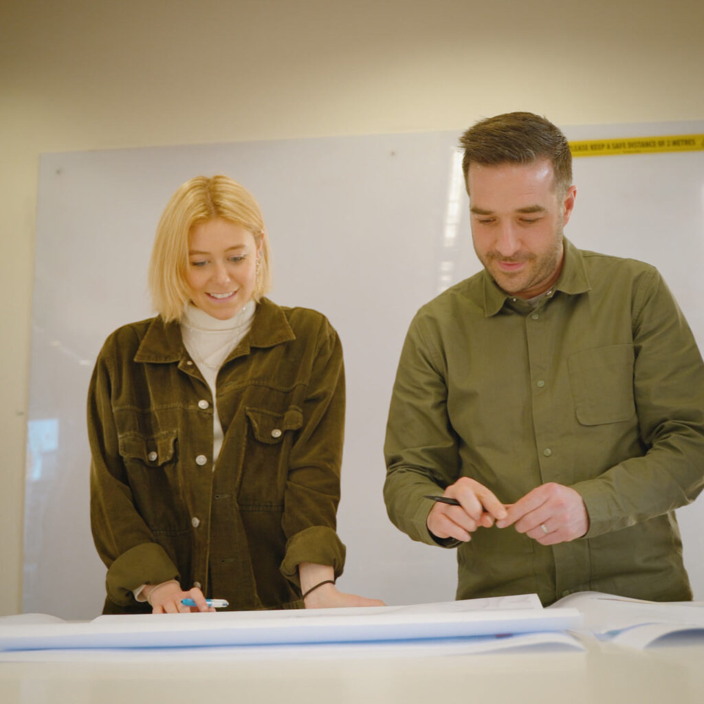 Creative Associate Ollie Howitt smiles as she looks at plans for SEE MONSTER.